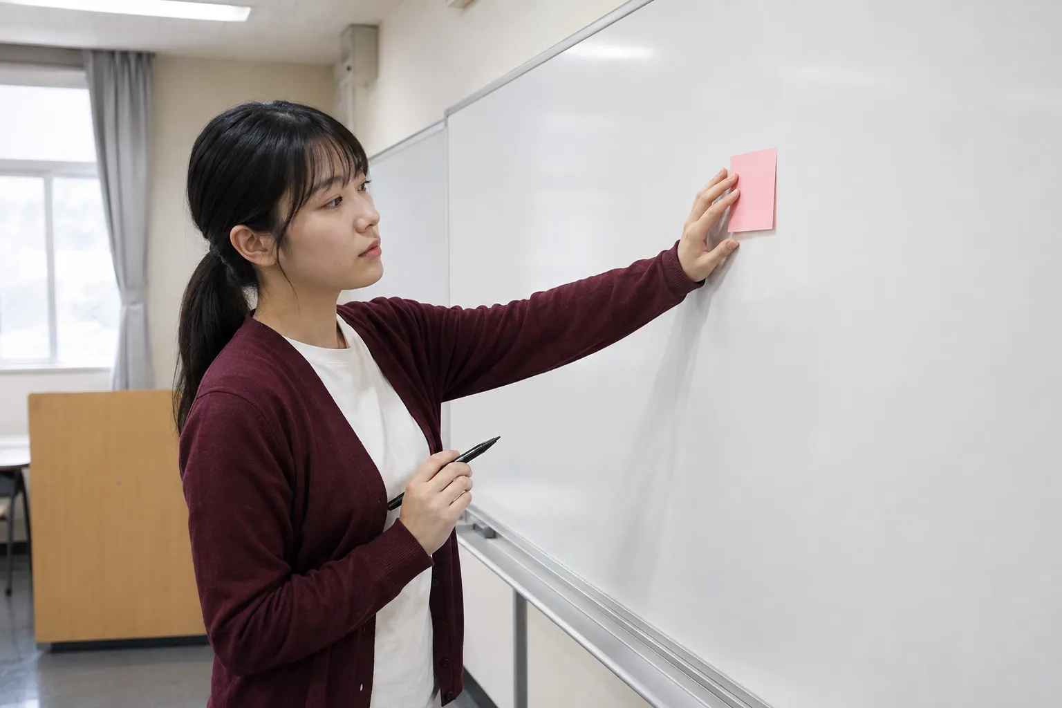 教室のホワイトボード前で商品企画を整理する架空の学生